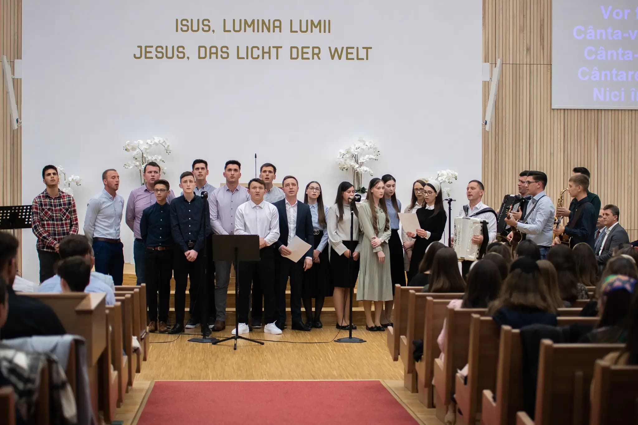 Corul tinerilor pe scenă, sub bannerul „Isus, lumina lumii”, la conferința de tineret din Brunn am Gebirge