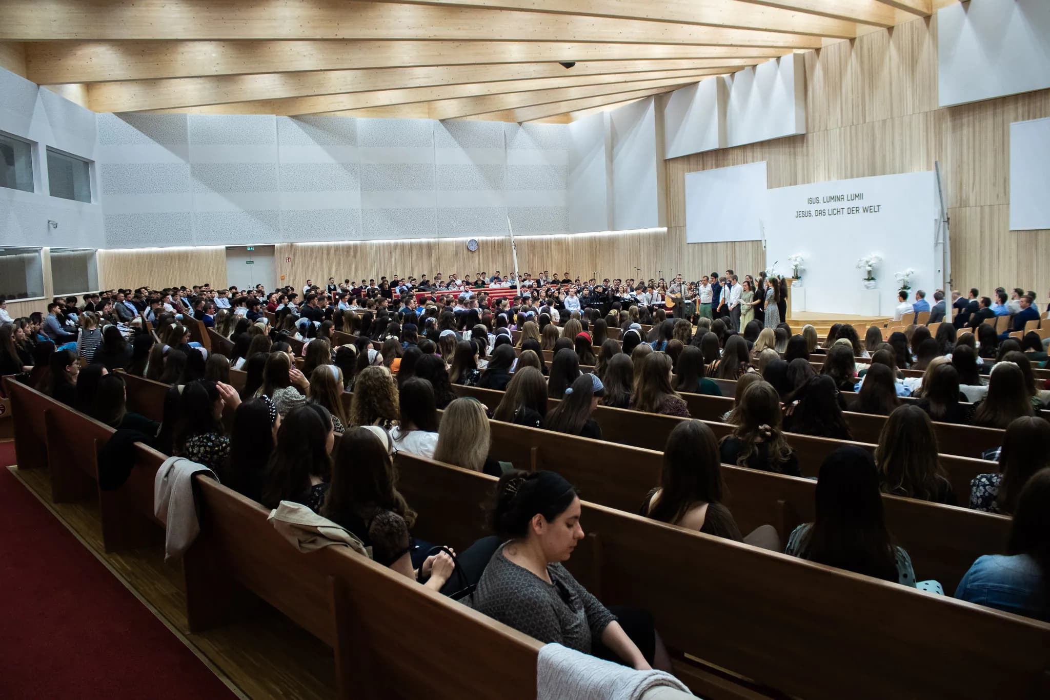 Sala unei biserici plină de tineri la o conferință de tineret
